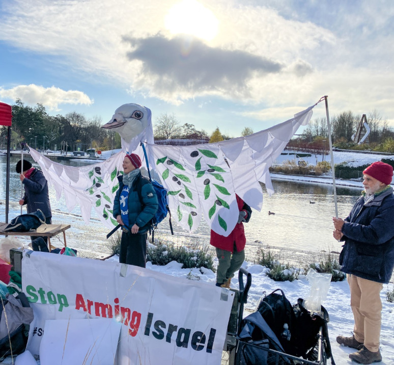 A snow covered Telford by a river with a huge homemade dove as a banner