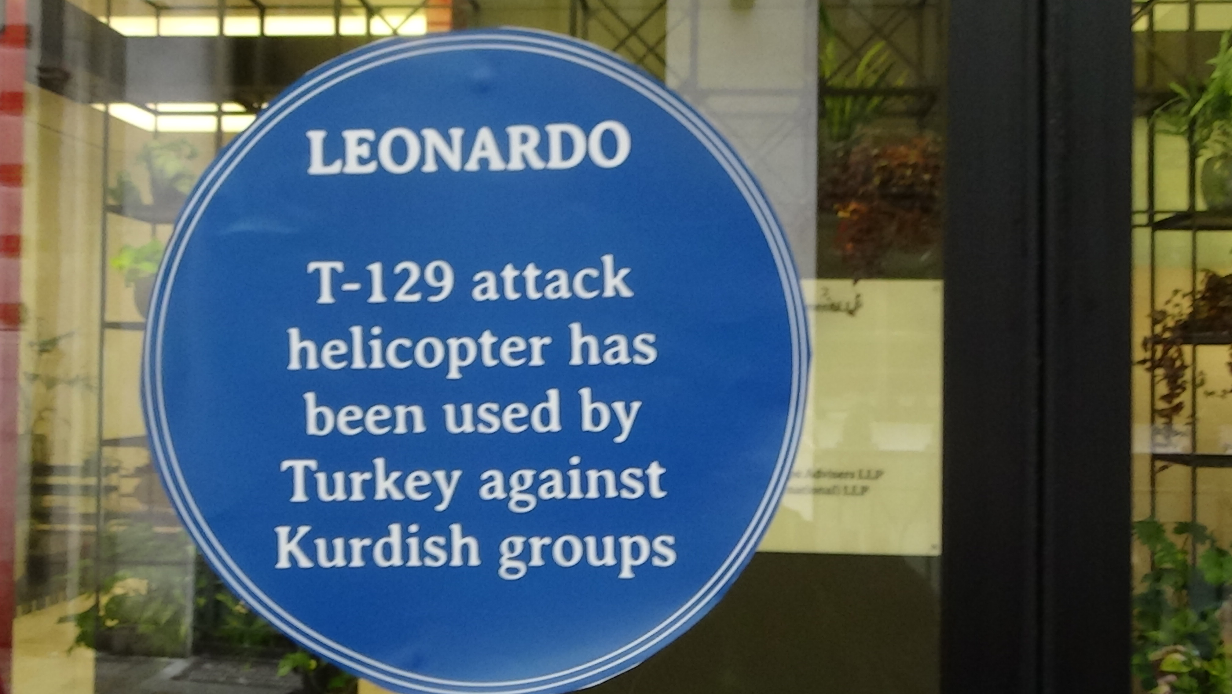 "Blue Plaque" on the offices of Leonardo. Plaque reads "T-29 attack helicopter has been used by Turkey against Kurdish groups"