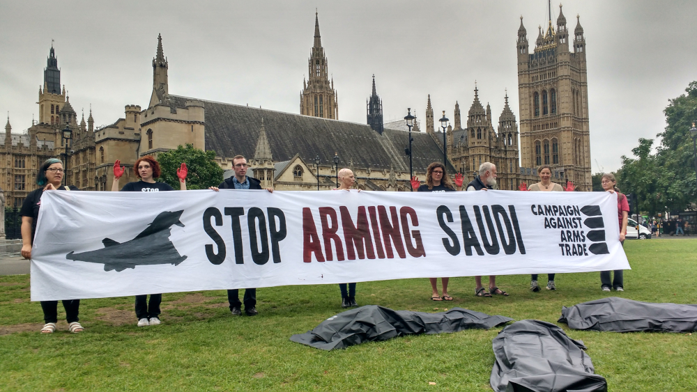 Campaigners hold a Stop Arming Saudi banner outside Parliament with a series of body bags in front of them