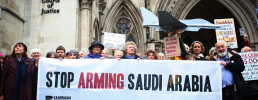 Image of a people and banner saying "Stop Arming Saudi Arabia". Outside the Royal Courts of Justice."