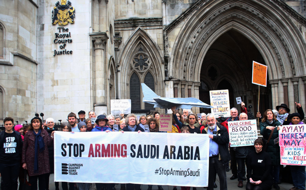 Campaigners hold a vigil outside the Royal Courts of Justice, behind a large banner saying Stop Arming Saudi
